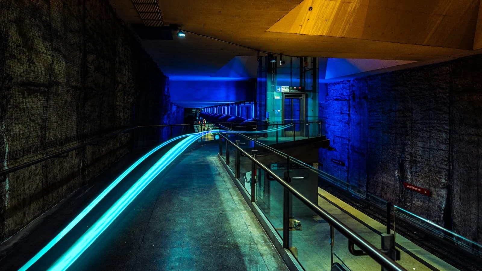 Blue light traces a route through an urban passage.