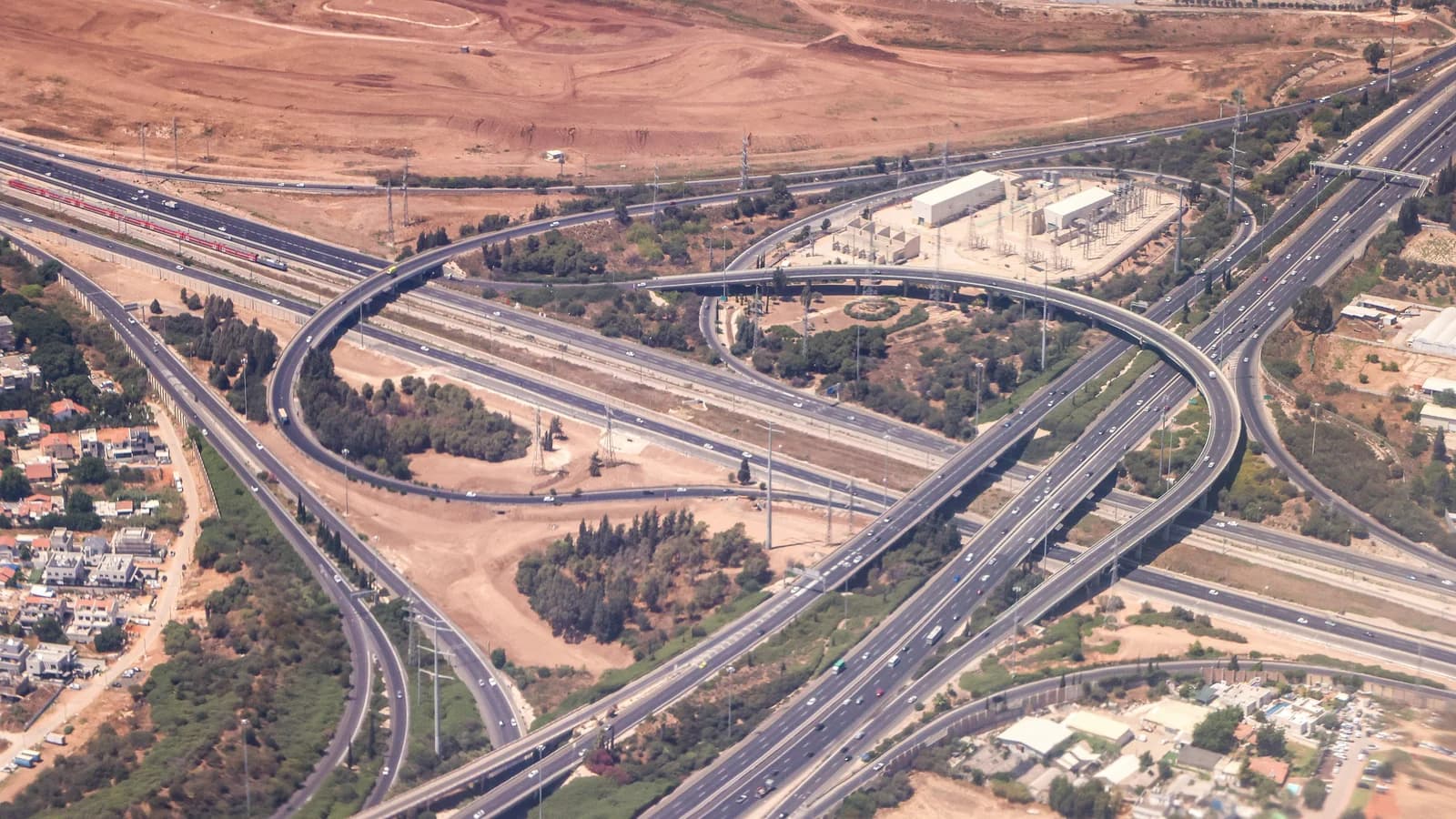 A highway interchange seen from above separates several crossing routes.