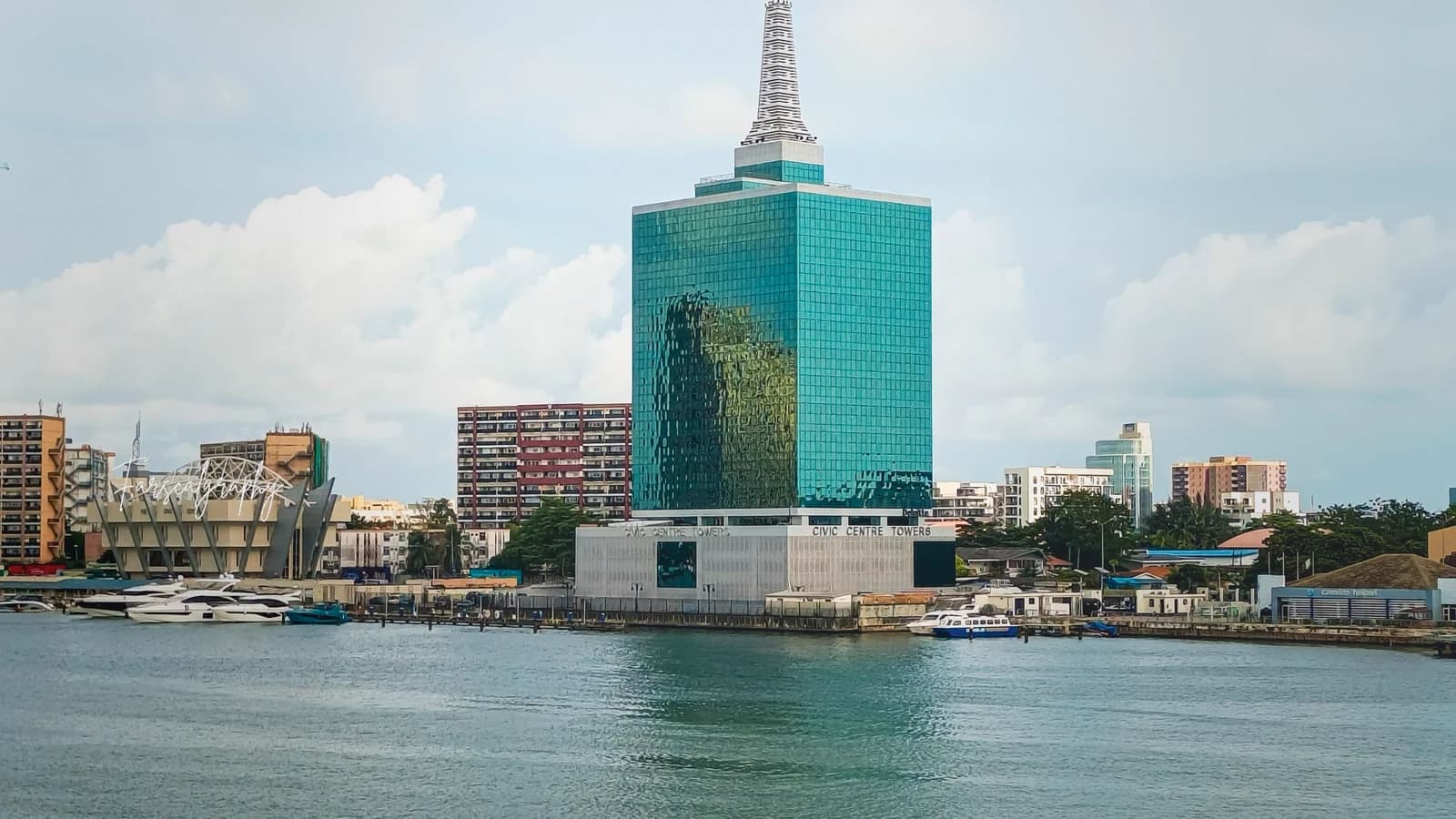 Lagos waterfront skyline includes boats and the city's distinctive green tower.